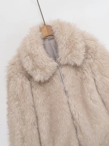 Détail de la texture en fausse fourrure et du col à revers sur la veste beige