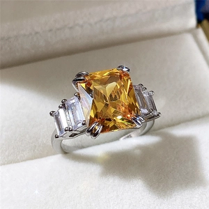 Macro view of luxury rectangular yellow zircon with side baguette stones on silver band