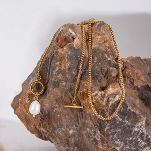 Golden stainless steel necklace with fresh water pearl pendant and T-bar clasp on stone