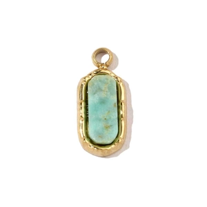 Détail d'un pendentif en acier titane doré avec une pierre naturelle verte