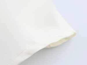 Détail de l'ourlet en dentelle blanche et des coutures professionnelles de la robe