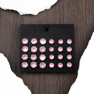 Sparkling pink round zircon stud earrings set on a black display card over stone