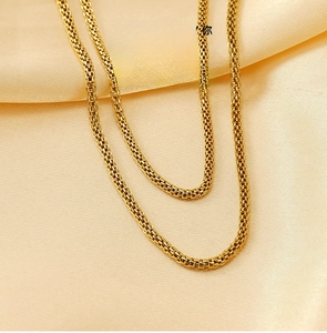 Close-up of 18K gold plated stainless steel mesh chain on elegant champagne silk fabric