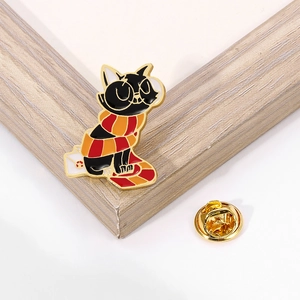 Detailed close-up of cartoon black cat metal brooch with scarf and gold clutch pin back