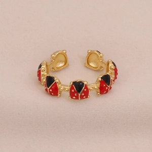 Detailed close-up of golden adjustable ring featuring cute red and black enamel ladybugs