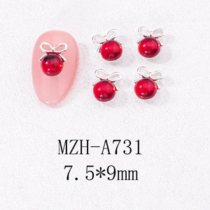 Détails macro de charmes de nœud rouge pour ongles avec base argentée et perles œil-de-chat