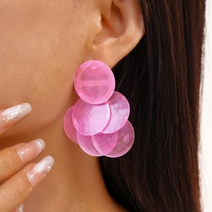 Close-up of pink layered round resin earrings on model for a trendy summer look