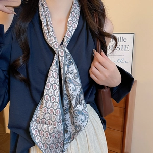 Detail of white paisley print scarf necklace draped elegantly on a model's neck
