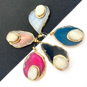 Detail of natural agate geode pendants in various colors with gold-plated edges
