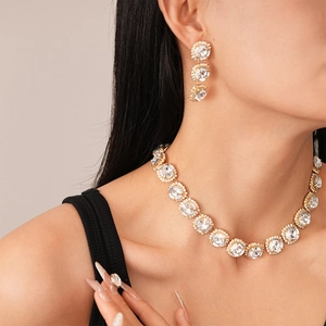 Close-up of luxury gold necklace and earring set with sparkling round rhinestones
