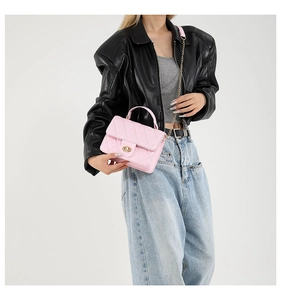 Sac bandoulière matelassé rose avec fermoir doré et bandoulière chaîne sur modèle