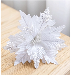 Close-up of a white velvet poinsettia flower with silver sequins for Christmas decor