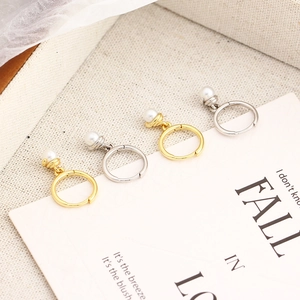Detailed close-up of gold and silver hoop earrings with dangling small pearl accents