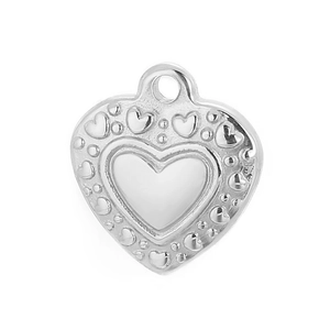 Close-up of silver heart pendant with embossed small hearts and white inlay
