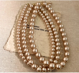 Detailed view of champagne pearl necklace featuring a triple-layer design and lobster clasp