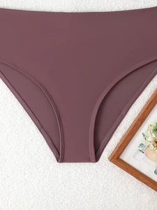 Detailed flat lay of deep purple bikini bottoms with premium seamless stitching edges