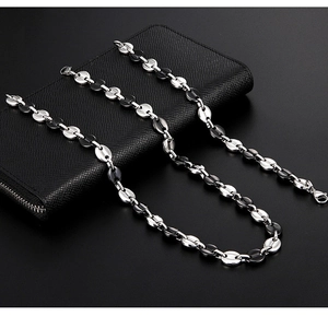 Detailed macro shot of bicolor silver and black coffee bean link chain on leather wallet