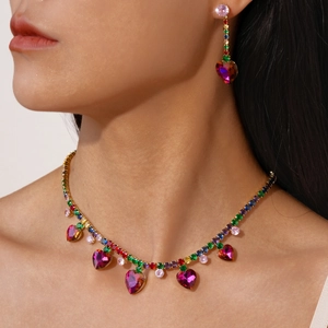 Close-up of luxury heart tassel necklace and earrings set with colorful crystals