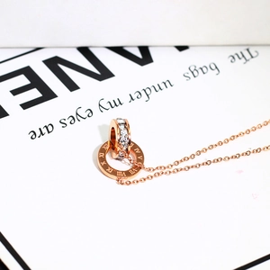 Detailed shot of rose gold double interlocking rings necklace with Roman numerals and crystals