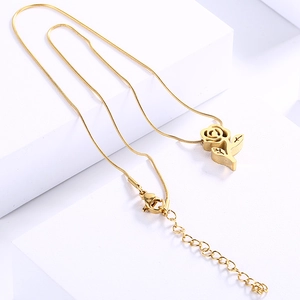 Golden snake chain necklace featuring a delicate rose pendant on white geometric background