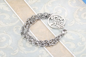 Detailed view of silver stainless steel double-layer bracelet with tree of life pendant