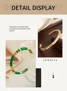 Macro view of vintage enamel gold-plated cuff bracelet featuring green and beige stripes