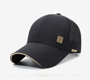 Detail view of black mesh baseball cap side with gold metallic emblem and sport tag