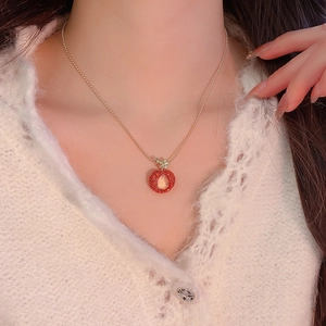 Close-up view of a sweet resin apple pendant necklace featuring sparkly red zircon details