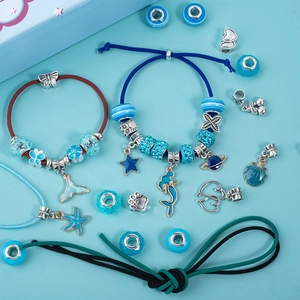 Detail of DIY ocean-themed bracelet set with blue mermaid pendants and silver beads