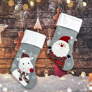 Detailed view of Christmas stockings with Santa and reindeer embroidery on rustic wood