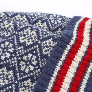 Navy blue winter knit beanie with Nordic snowflake pattern and pom-pom detail