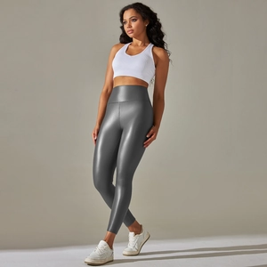 Gray high-waisted faux leather leggings with matte finish on a fitness model in studio