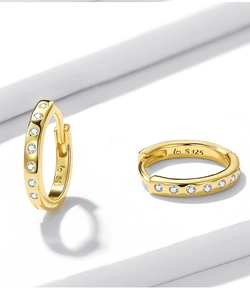 Macro shot of 925 sterling silver gold plated hoop earrings with inlaid white zircons