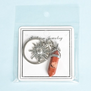 Natural crystal stone sun keychain with red hexagonal pillar pendant on display card
