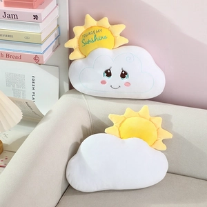Detail of plush sun and cloud pillows with embroidery on a cozy living room sofa