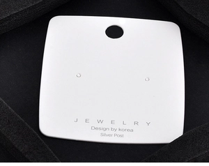 Macro shot of white jewelry display card with Silver Post and Design by Korea text