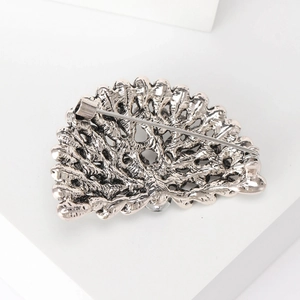 Back view of silver peacock brooch showing pin mechanism and detailed relief texture