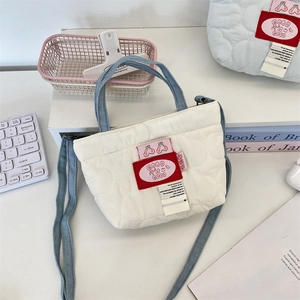 Détail du sac bandoulière blanc matelassé avec sangles bleues et décor GOOD is GOOD