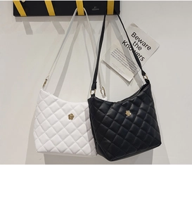 Detail of quilted PU leather shoulder bags in black and white with golden flower buckles