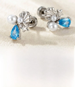 Detailed view of starfish and shell stud earrings with blue zircon in titanium steel