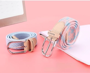 Detail view of woven elastic belts with polished metal buckles and leather embossed tips