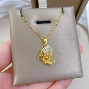 Macro shot of gold butterfly necklace with opal stone and zircon crystal details