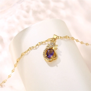 Elegant gold necklace featuring a purple amethyst pendant with zircon crystals on a display
