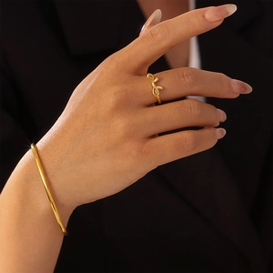 Polished 18K gold PVD coated stainless steel bow ring and sleek bangle jewelry set for women