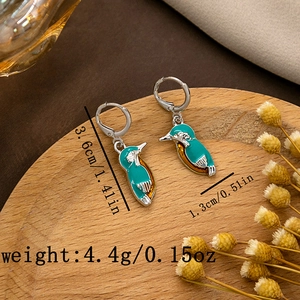 Detail view of kingfisher earrings with size and weight specs on a rustic wooden tray