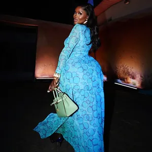 Detail of blue circle print mesh dress and pale green leather handbag with gold buckle