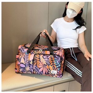 Detail showing colorful leaf pattern and Travel Fashion label on purple travel tote bag