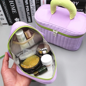 Detail view of purple quilted cosmetic bag interior with green zipper and mesh pocket