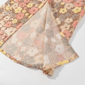 Detail view of intricate floral sequin embroidery on mesh for evening dress