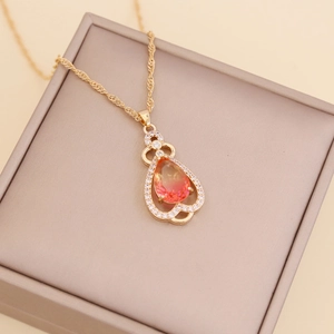 Detail of pear-shaped pendant with orange-pink gradient gem and white rhinestones